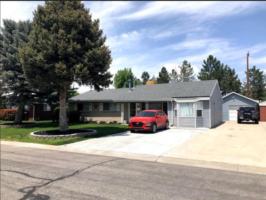 una casa con un coche rojo aparcado en una entrada en The Oquirrh Retreat, en Taylorsville