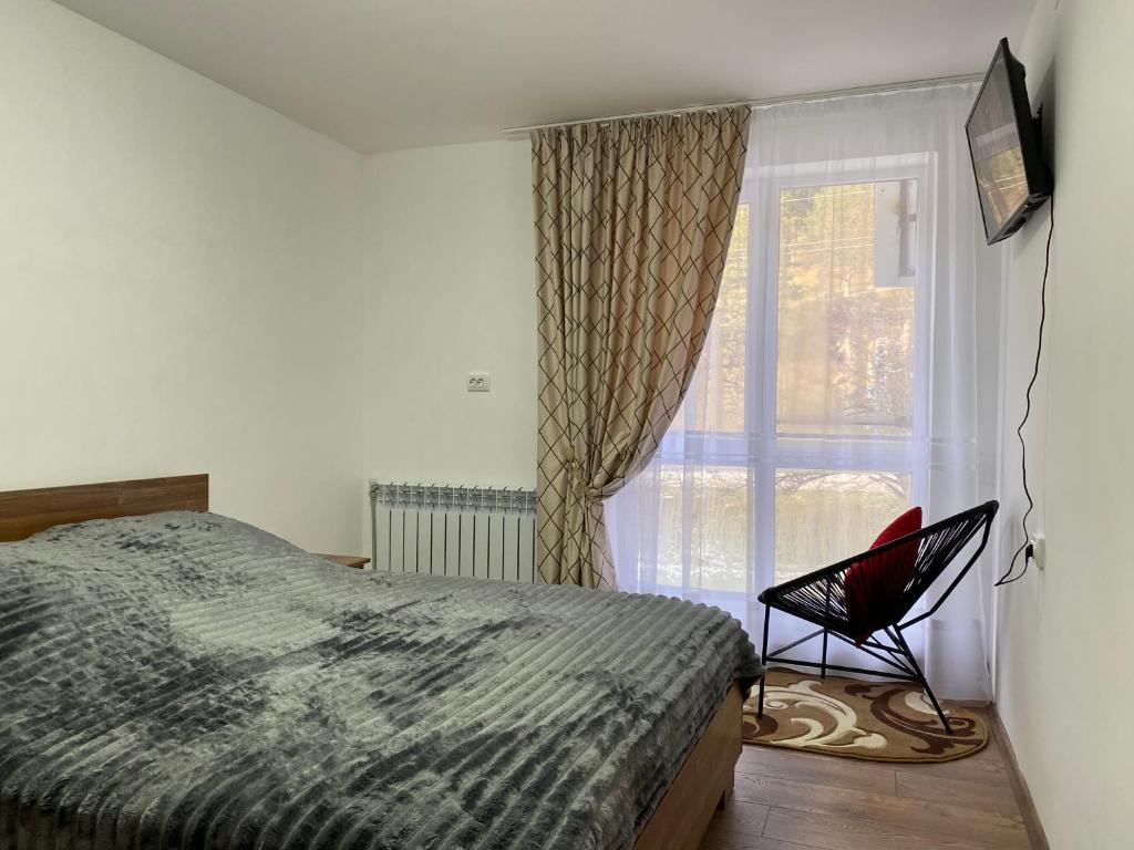 ヤレムチャにあるWeekend houseのベッドルーム1室(ベッド1台、窓の前に椅子付)