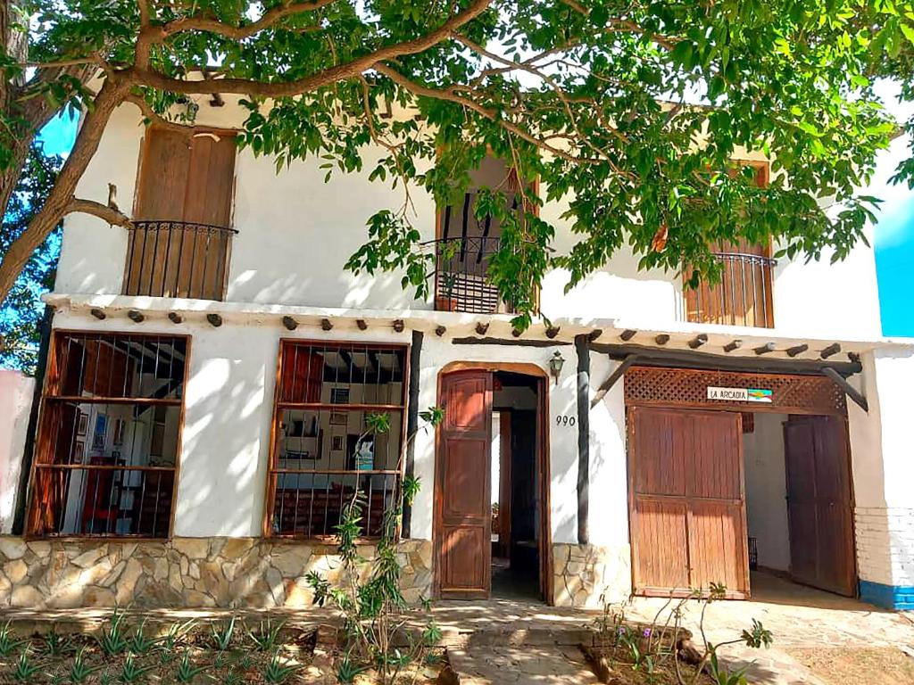 an old house with two doors and a tree at Posada la Arcadia in Pedro Gonzalez