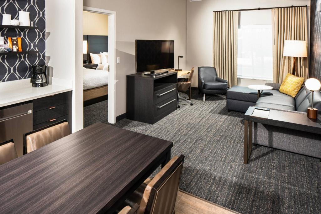 ein Hotelzimmer mit einem Wohnzimmer mit einem Sofa und einem Tisch in der Unterkunft Residence Inn Las Vegas South&#47;Henderson in Las Vegas