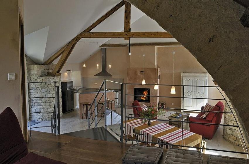 Il comprend un salon et une cuisine avec une table et des chaises. dans l'établissement Gîte de Caractère la Grange, à Buzeins