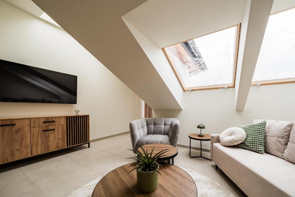 a living room with a couch and a tv at Apartament Park Zdrojowy 11 - NOWOŚĆ in Rabka