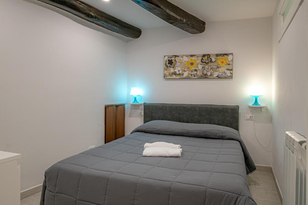 a bedroom with a gray bed with two blue lights at Pria de Mar 2 nuovo da giugno 2022 in Riomaggiore