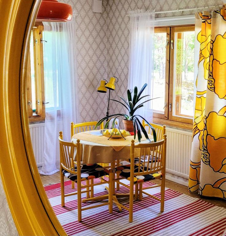 a dining room with a table and a mirror at Solvillan in Korppoo