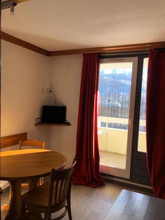 une salle à manger avec une table et une grande fenêtre dans l'établissement Résidence Les Bergers - maeva Home - Studio 4 personnes Budget MAE-9504, à Huez