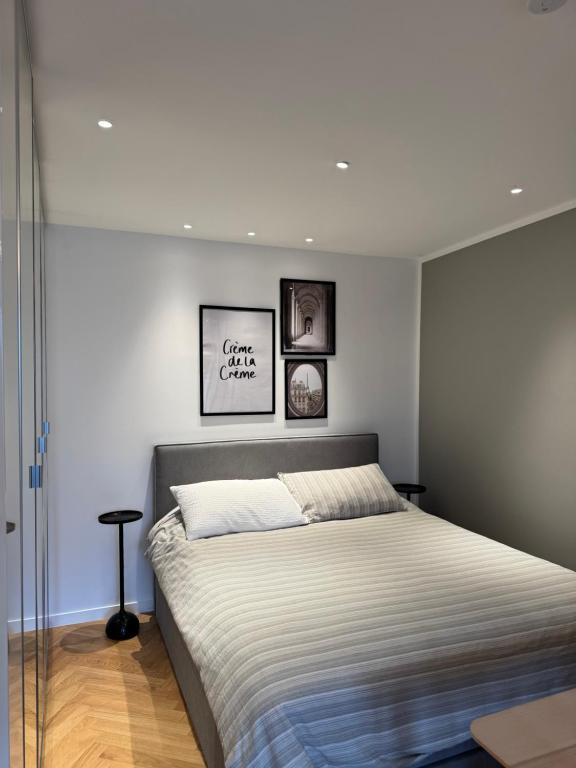 - une chambre avec un grand lit et 2 photos sur le mur dans l'établissement 2 bedroom apartment renovated in the heart of Paris, à Paris