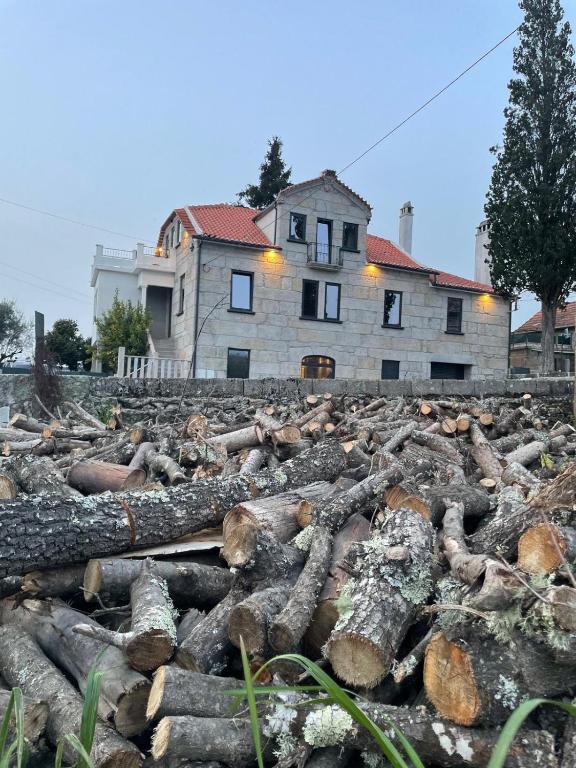 a pile of logs in front of a house at Casa Videira in Gouveia
