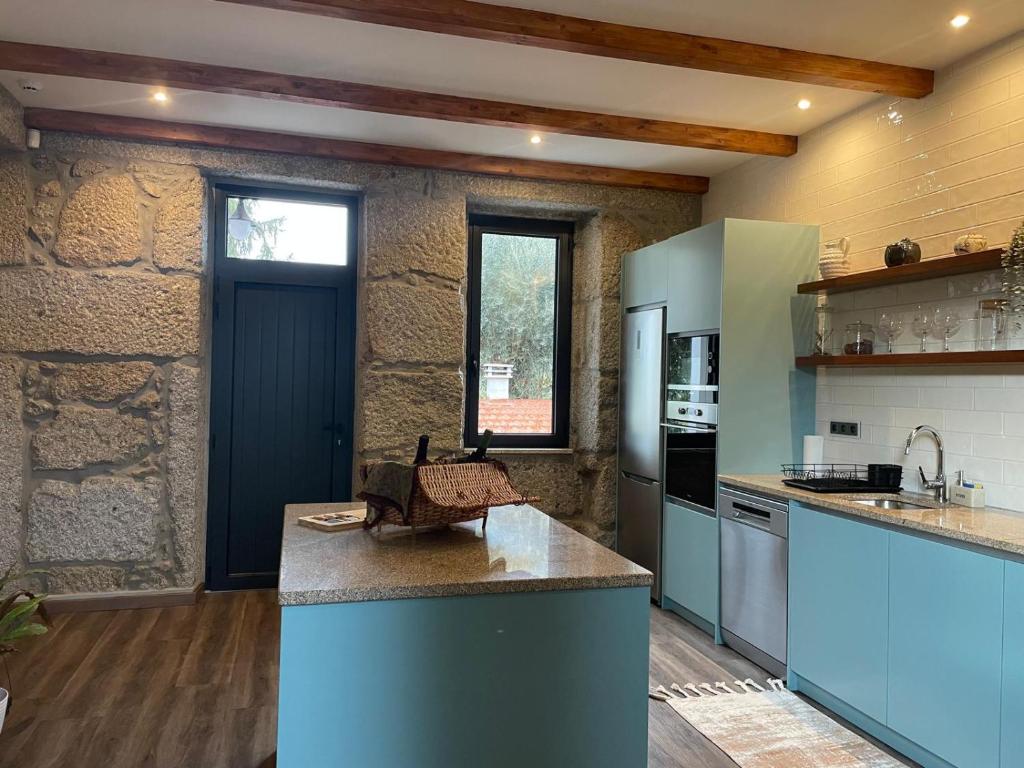 a kitchen with blue cabinets and a counter top at Casa Videira in Gouveia