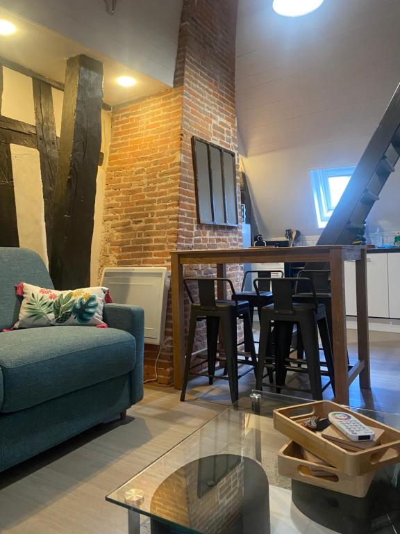 un salon avec un canapé et une table dans l'établissement La Luciole, à Honfleur