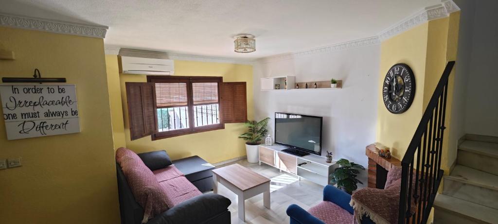 a living room with a couch and a tv at La Casita de Juana in Málaga
