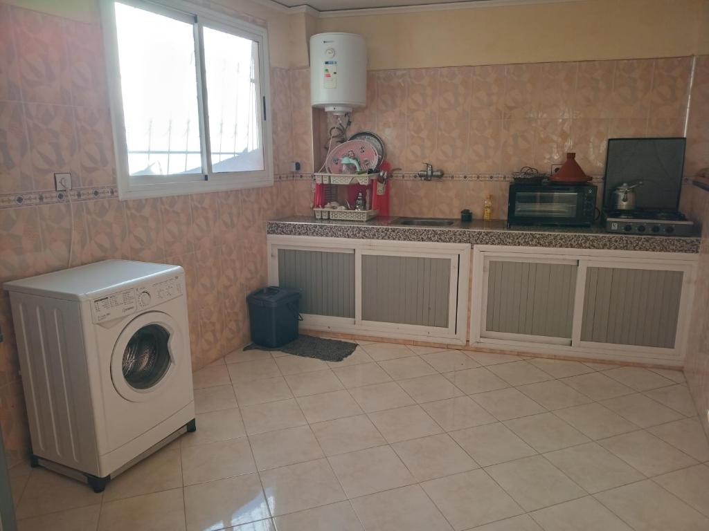 a kitchen with a washing machine and a window at Billa appart in Midelt