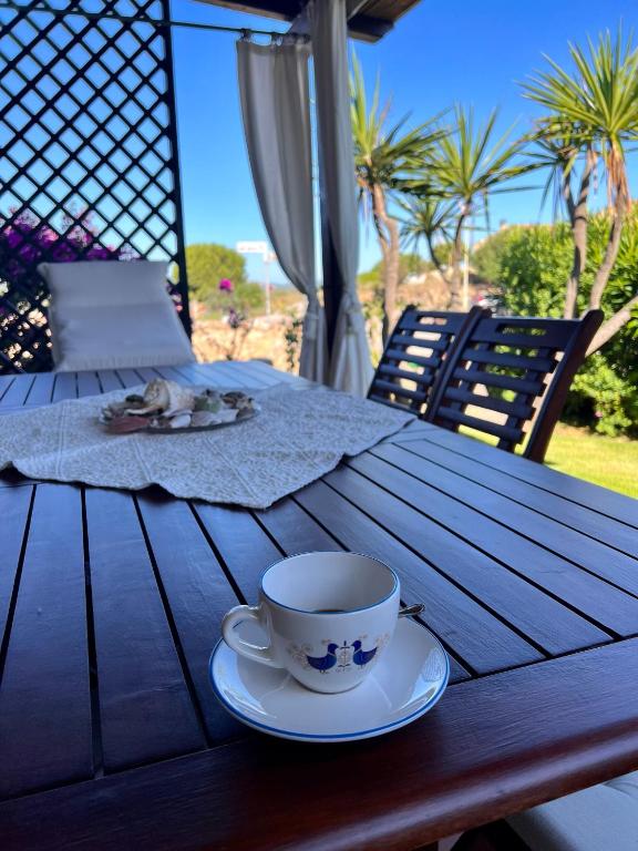 a cup of coffee sitting on a wooden table at Casa Lala in Palau