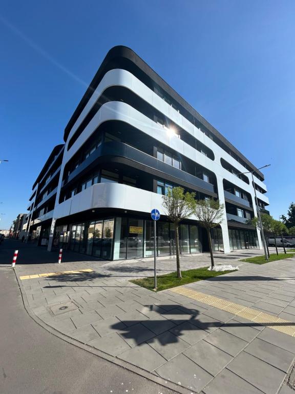 a large black and white building on a street at Premium Apartamenty Grunwaldzka 25A in Bydgoszcz