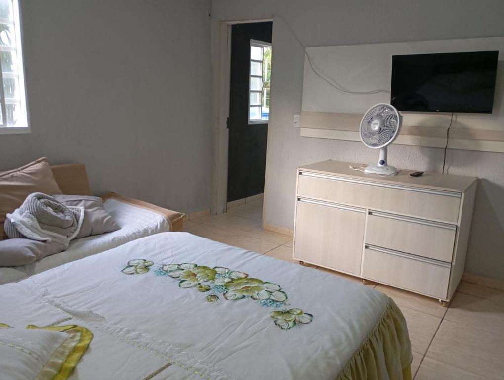 a bedroom with a bed with a fan and a dresser at Apto n.09 condominio custo beneficio. in Brasília