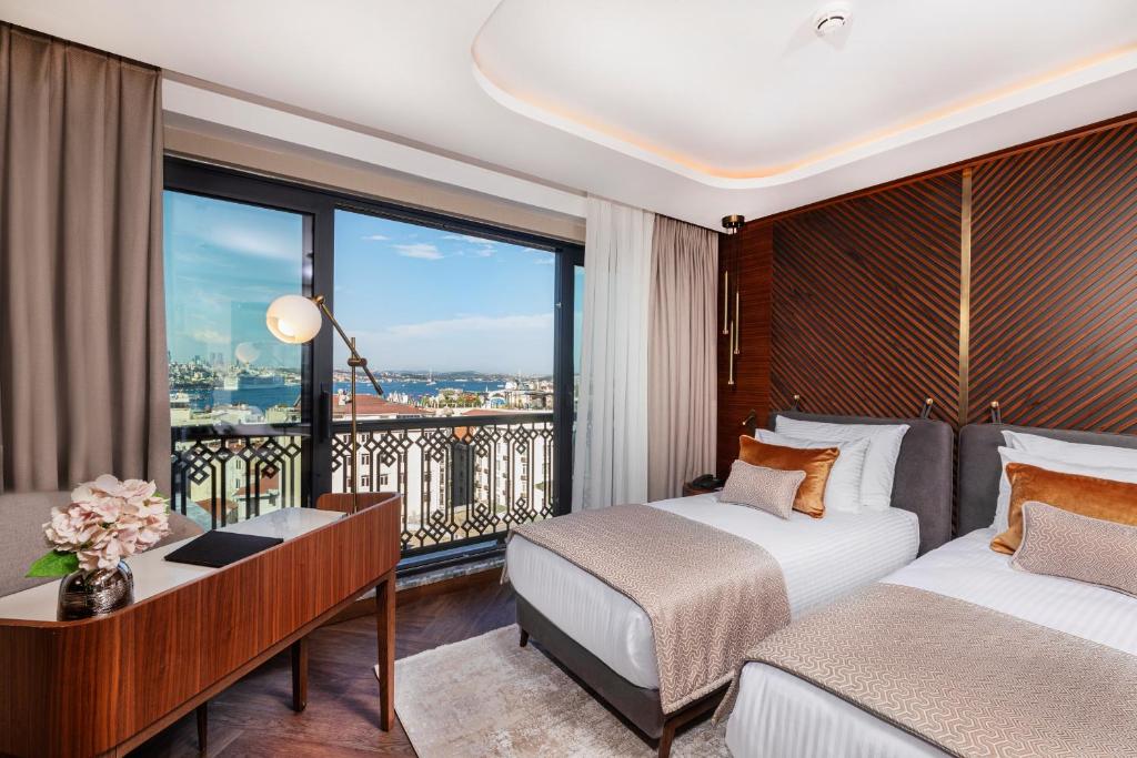 a hotel room with two beds and a balcony at Levni Premium Hotel Istanbul Old City in Istanbul