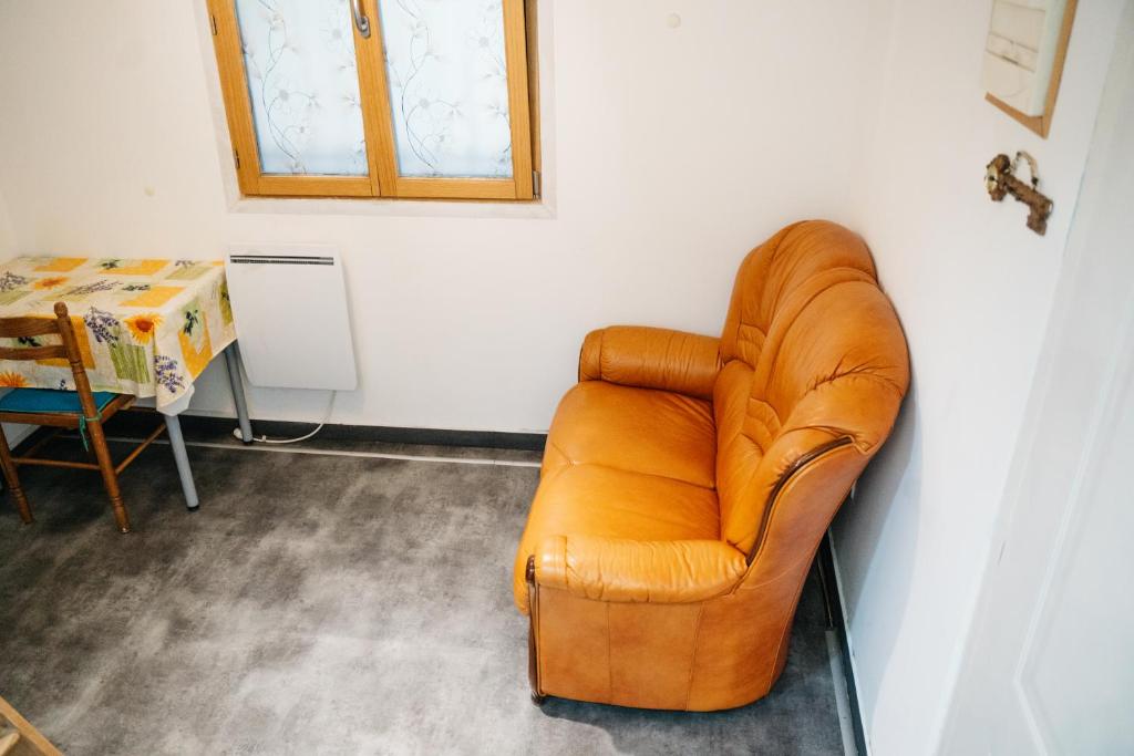 un fauteuil en cuir brun dans une chambre avec une table dans l'établissement Studio avec Mezzanine, à Saint-Maur-des-Fossés