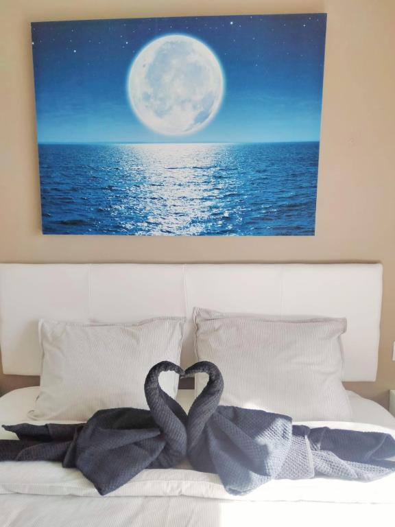 Zwei Schwäne bilden ein Herz auf einem Bett mit dem Mond in der Unterkunft Bahia Sol Deluxe in Caleta de Fuste