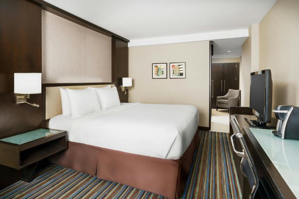 a hotel room with a bed and a television at Courtyard New York Manhattan/Times Square in New York