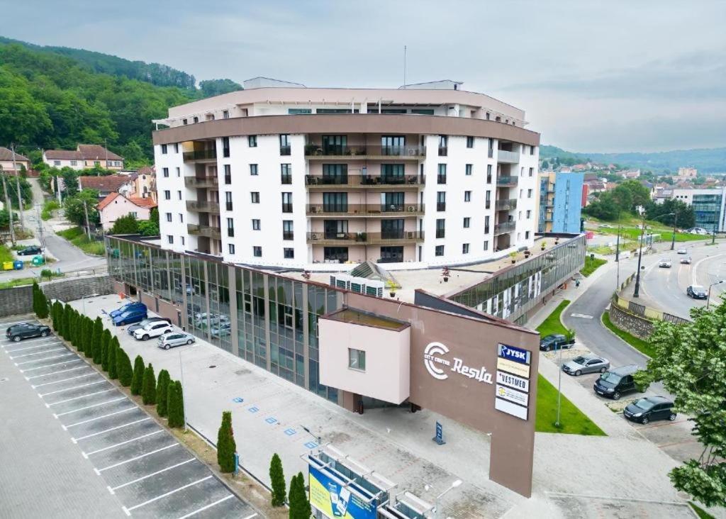 a large building in a city with a parking lot at CityCenter Heart - Ultracentral & Panoramic View in Reşiţa