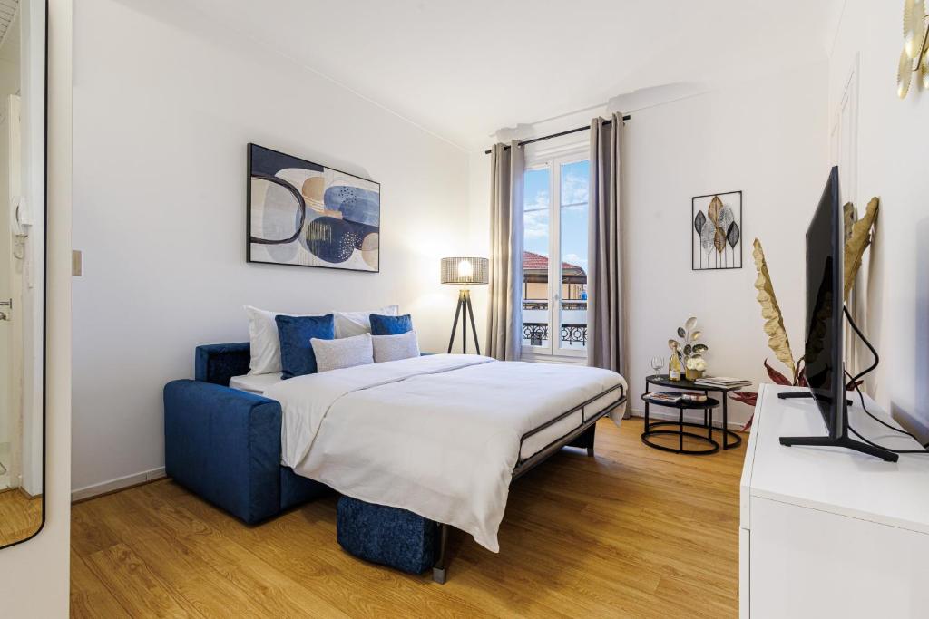 a bedroom with a king sized bed and a television at Cosy Studio, close to Monaco Train Station in Beausoleil