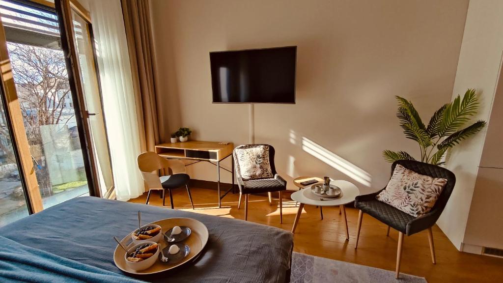 a room with a bed and chairs and a television at Residence in Belgrade