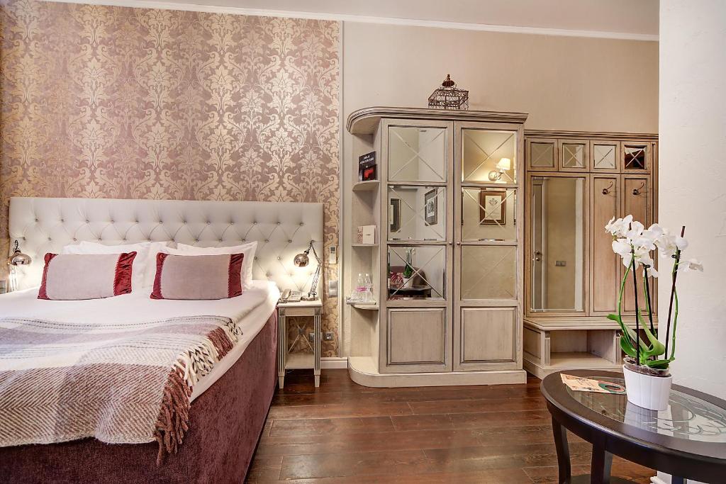 a bedroom with a large bed and a table at Pushka INN hotel in Saint Petersburg