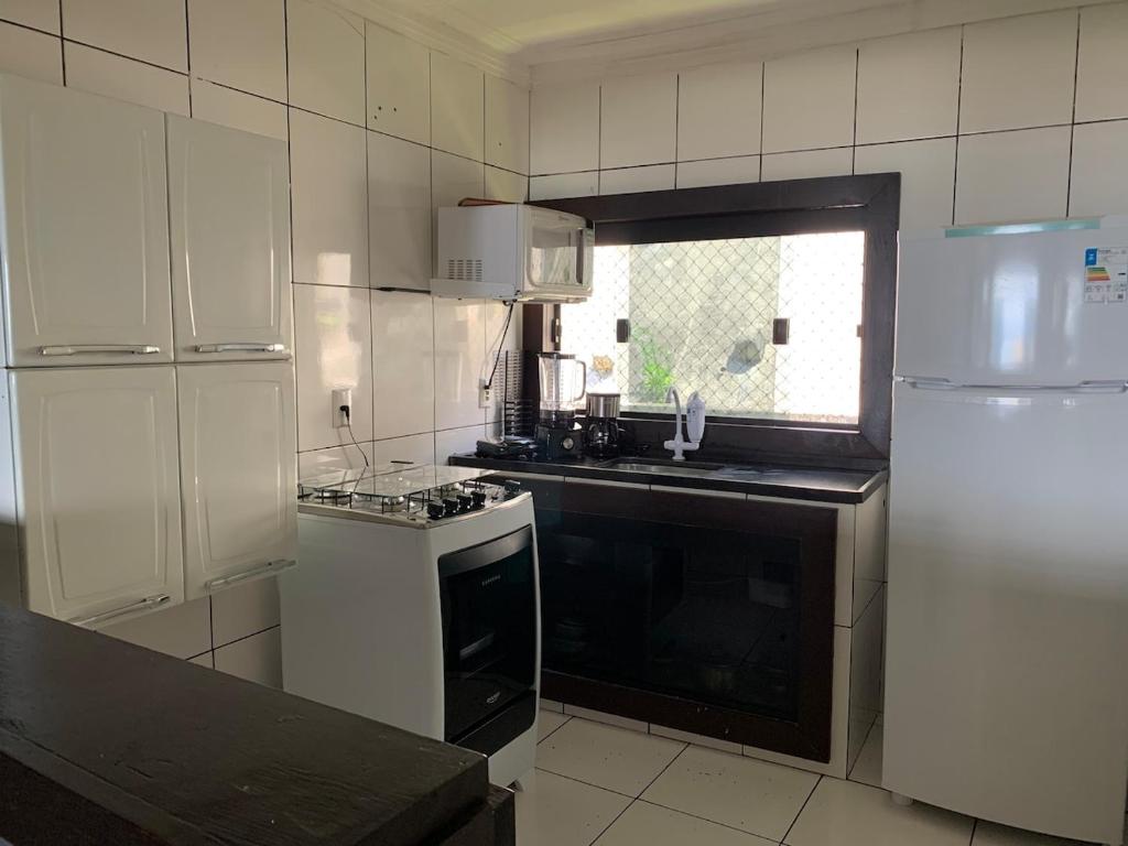 a kitchen with a stove and a white refrigerator at Apartamento Vista Praia do Anil in Angra dos Reis