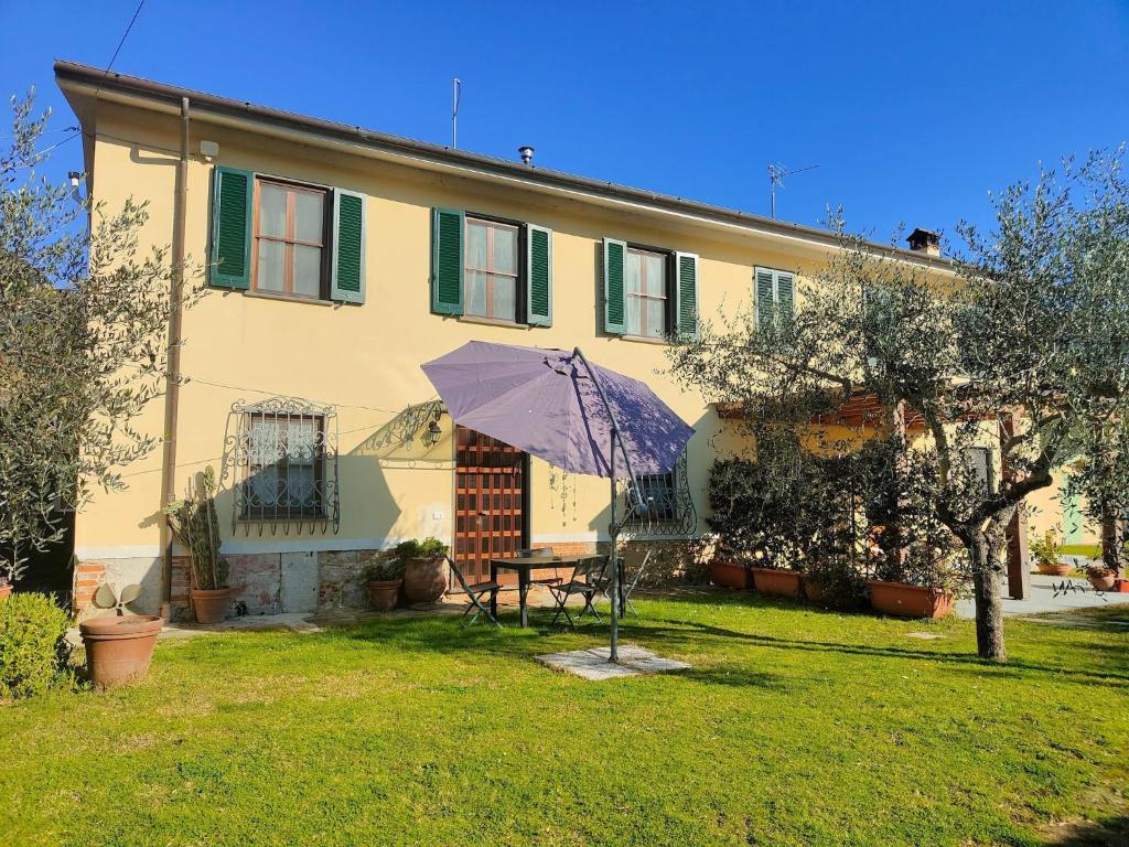 a house with a table and an umbrella in the yard at Holiday Home in Camaiore near Sandy Beaches in Camaiore