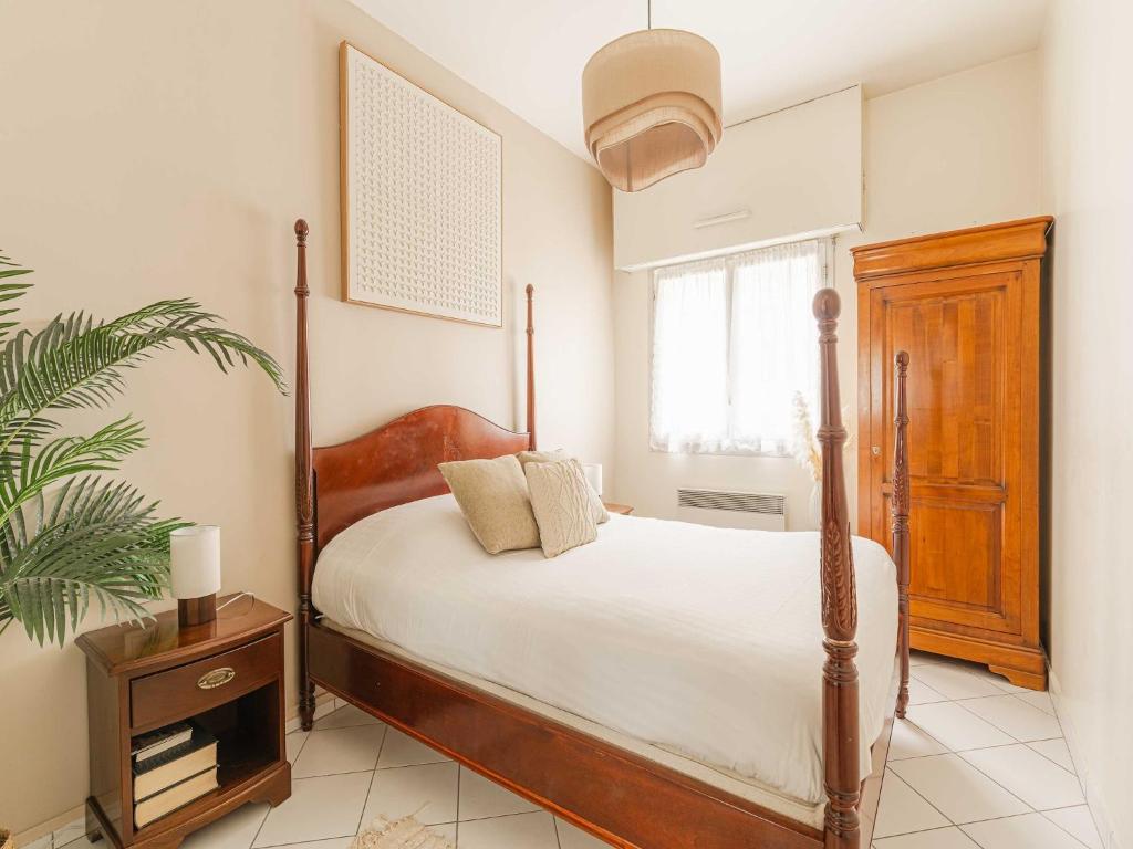 - une chambre avec un lit et une plante dans l'établissement Modern Apartment with Terrace Trouville, à Trouville-sur-Mer