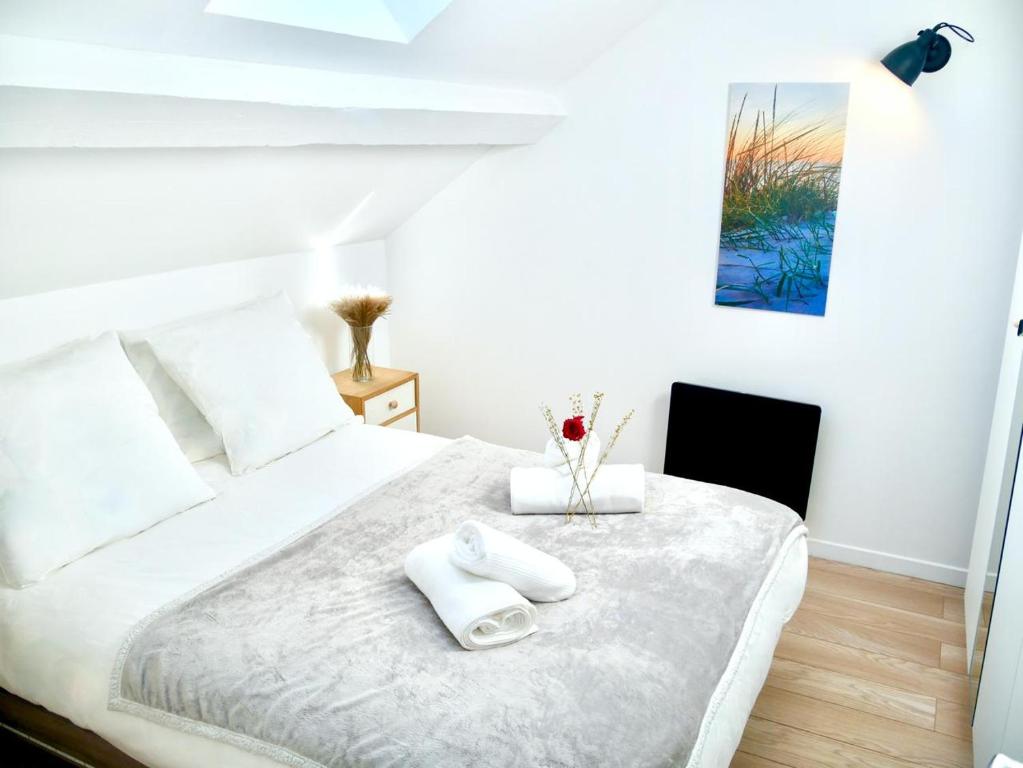 - un lit blanc avec 2 serviettes blanches dans l'établissement Haven Home, à Melun