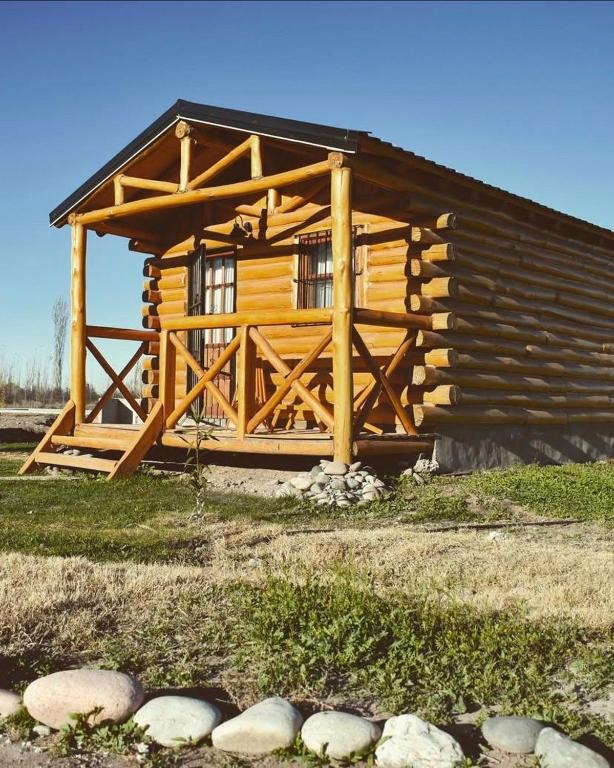 a log cabin with a window and some rocks at Finca La Vilina - Cabaña Aurora in San Rafael