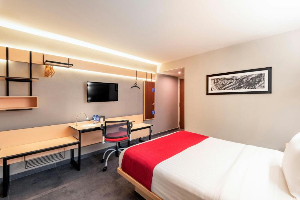 una camera d'albergo con letto, scrivania e computer di City Express by Marriott Tuxpan a Tuxpan de Rodríguez Cano