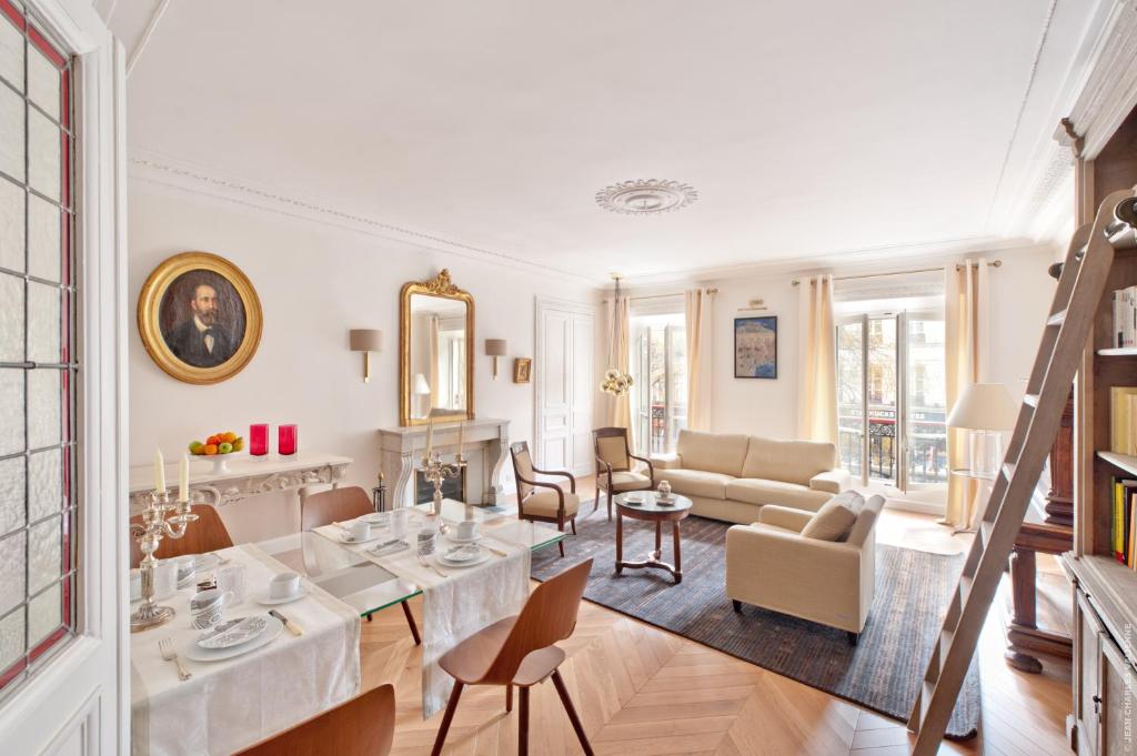 uma sala de estar com uma mesa e um sofá em My Home For You Luxury B&B Adults Only em Paris