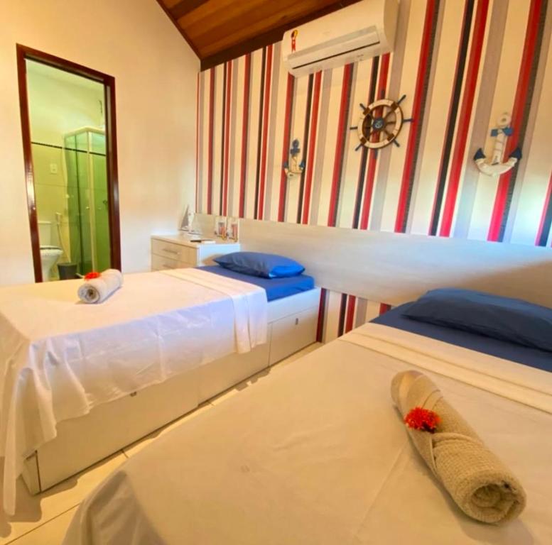 una camera da letto con due letti e uno specchio di Casa na praia dos carneiros em condomínio Village a Tamandaré