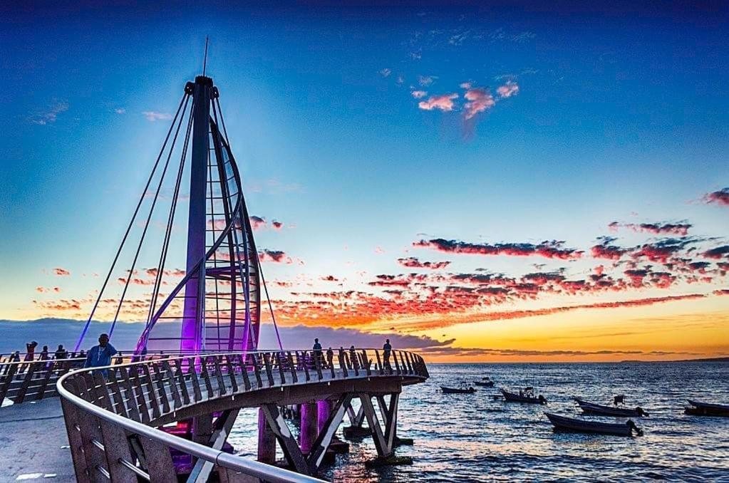 a bridge over the water with a group of people on it at Just Beachy PV in Puerto Vallarta
