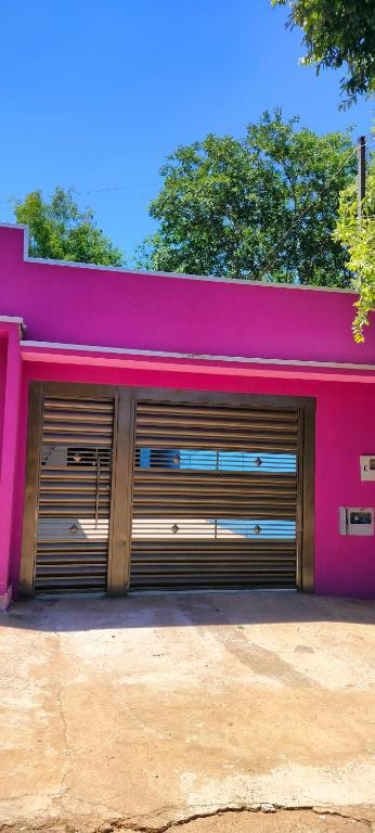 a pink building with two garage doors at Casa Roxa in Bonito