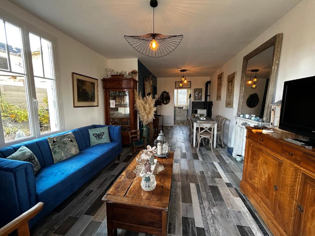un soggiorno con un divano blu e un tavolo di Charmante Maison 2 Chambres, Jardin et WIFI à La Roche-Posay - FR-1-541-158 a La Roche-Posay