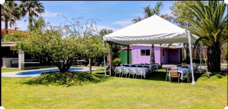 una mesa y sillas bajo una tienda blanca en un patio en Villas ARVEM 1, en La Sabana