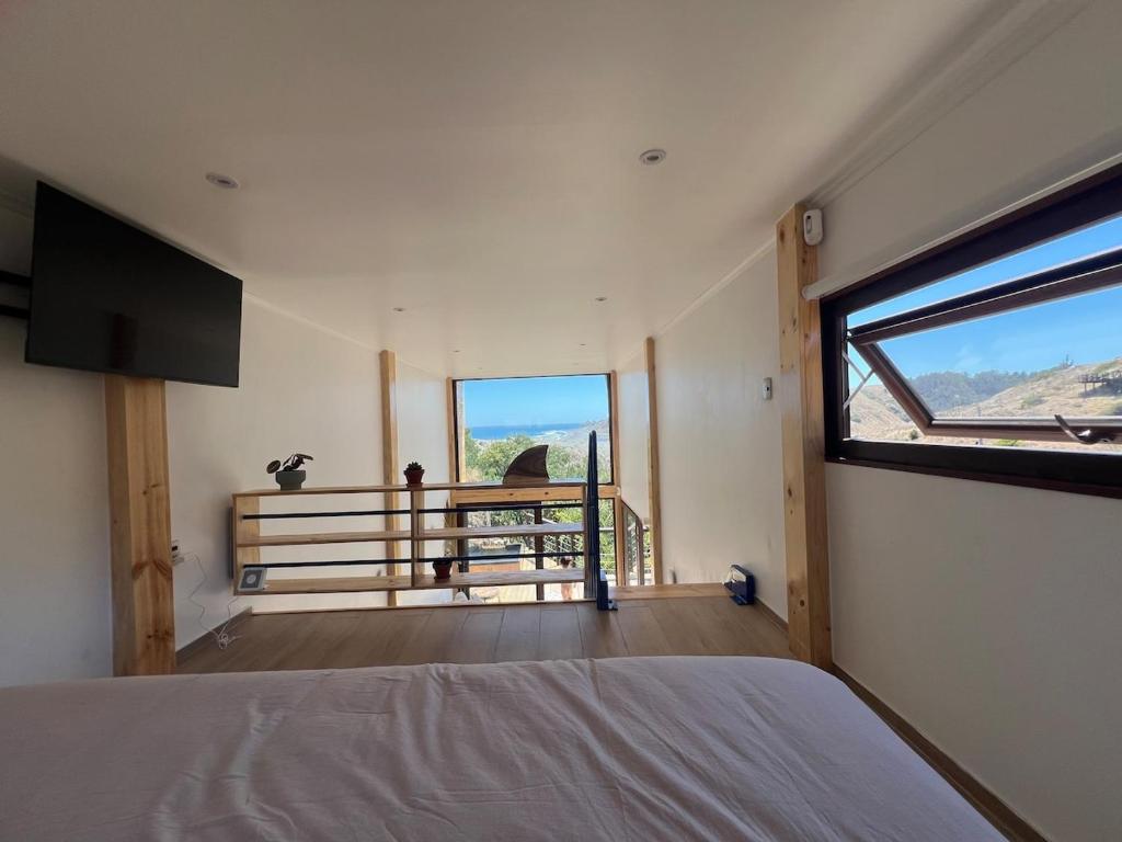 a bedroom with a bed and a large window at El Encanto, Loft en Matanzas in Matanzas
