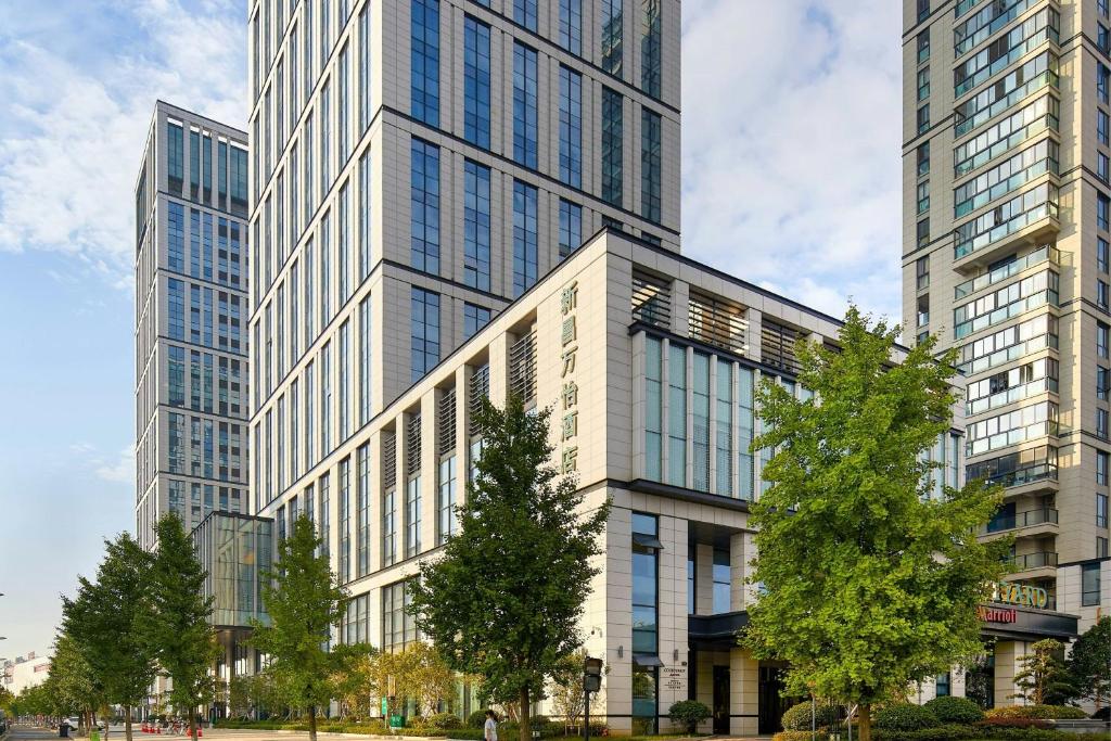 a large building with tall skyscrapers in a city at Courtyard by Marriott Xinchang in Xinchang