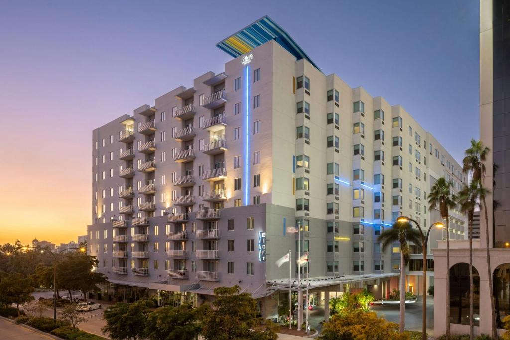 a large white building with a flag on top of it at Aloft Sarasota in Sarasota