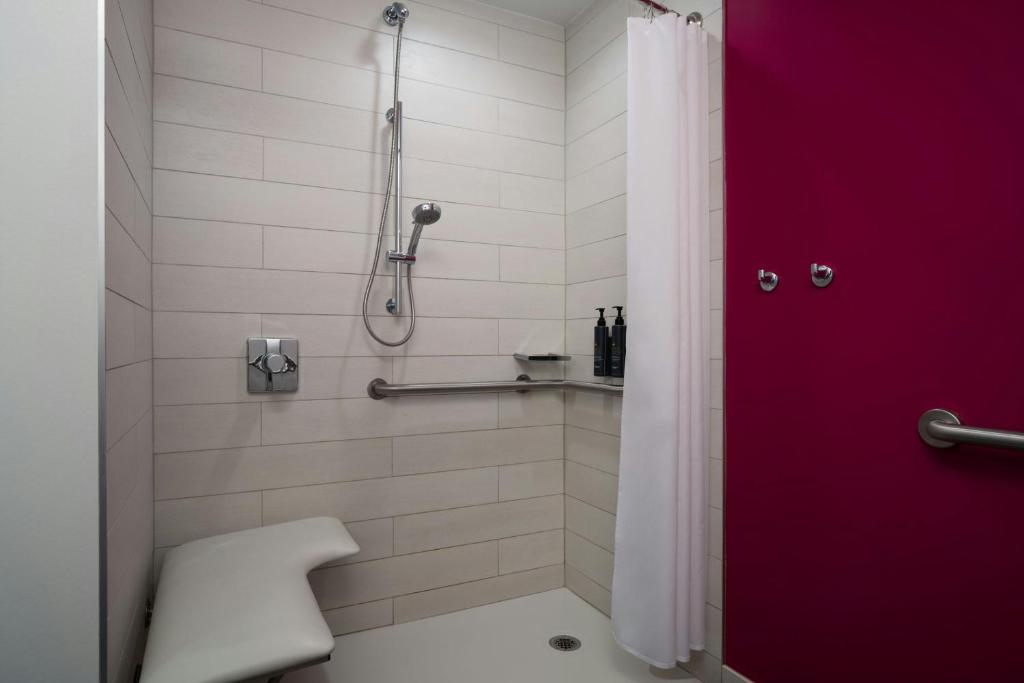 a bathroom with a shower with a red door at Aloft Sarasota in Sarasota