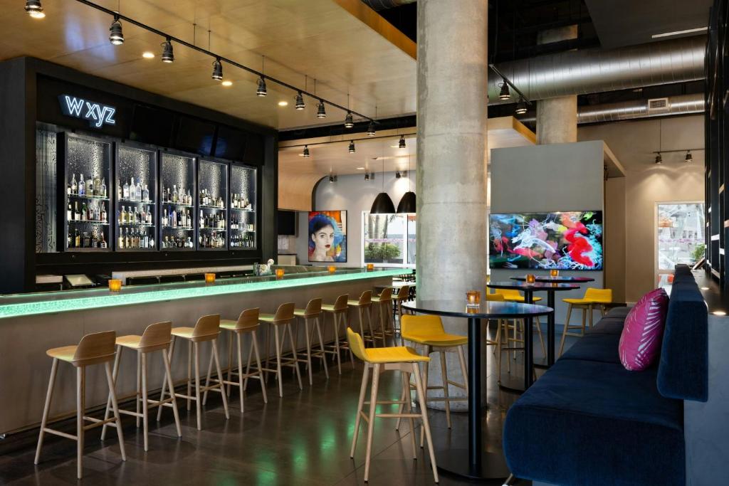 a bar in a restaurant with yellow stools at Aloft Sarasota in Sarasota