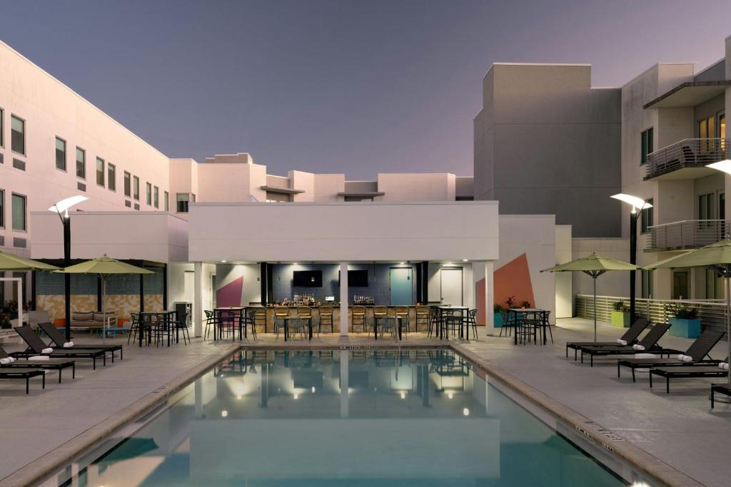 a pool in front of a building with chairs and tables at Aloft Sarasota in Sarasota