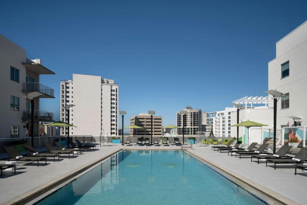 a swimming pool with chaise lounges and chairs at Aloft Sarasota in Sarasota
