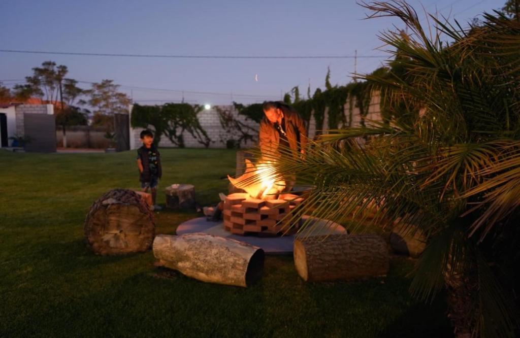 Un hombre parado junto a una fogata en un patio. en Villas ARVEM 2 enjoy nature, en Atlixco