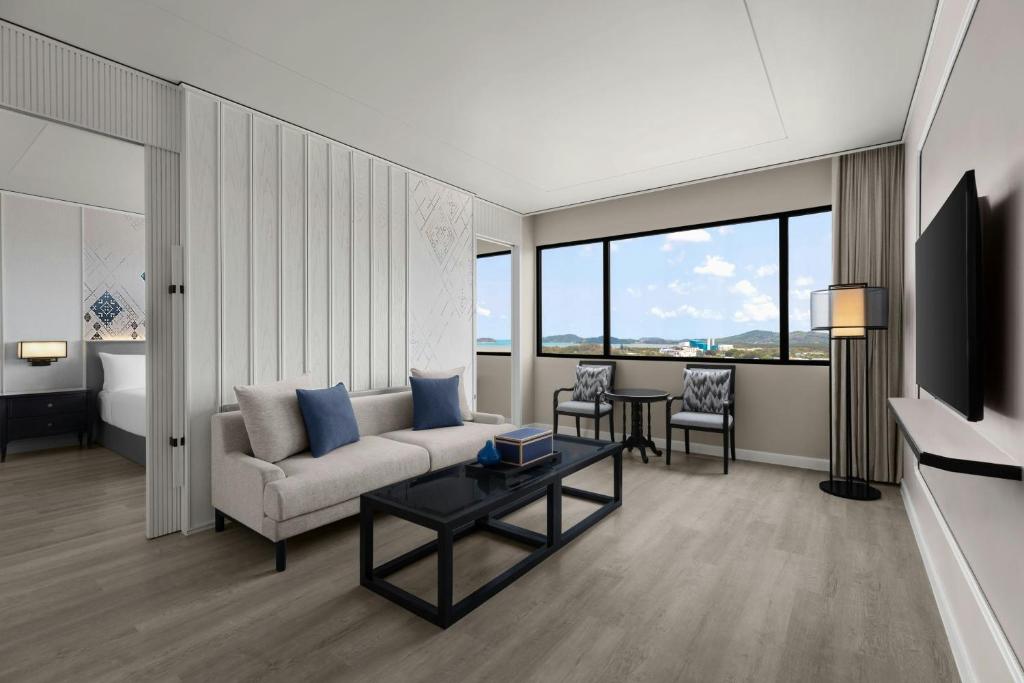 a living room with a couch and a table at Courtyard by Marriott Phuket Town in Phuket Town