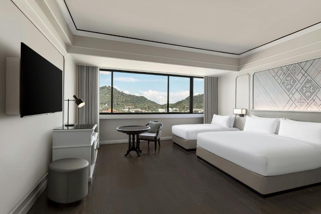 a hotel room with two beds and a table at Courtyard by Marriott Phuket Town in Phuket Town