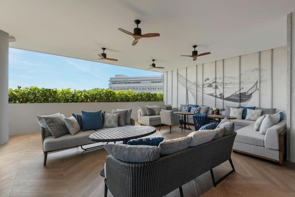 a living room with couches and chairs and a table at Courtyard by Marriott Phuket Town in Phuket Town