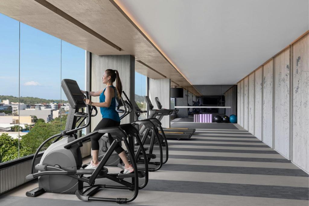 a woman riding on a treadmill in a gym at Courtyard by Marriott Phuket Town in Phuket Town